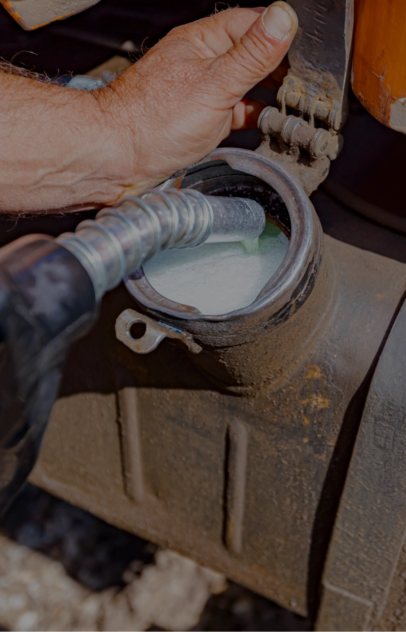 Fuel nozzle filling a construction vehicle tank.