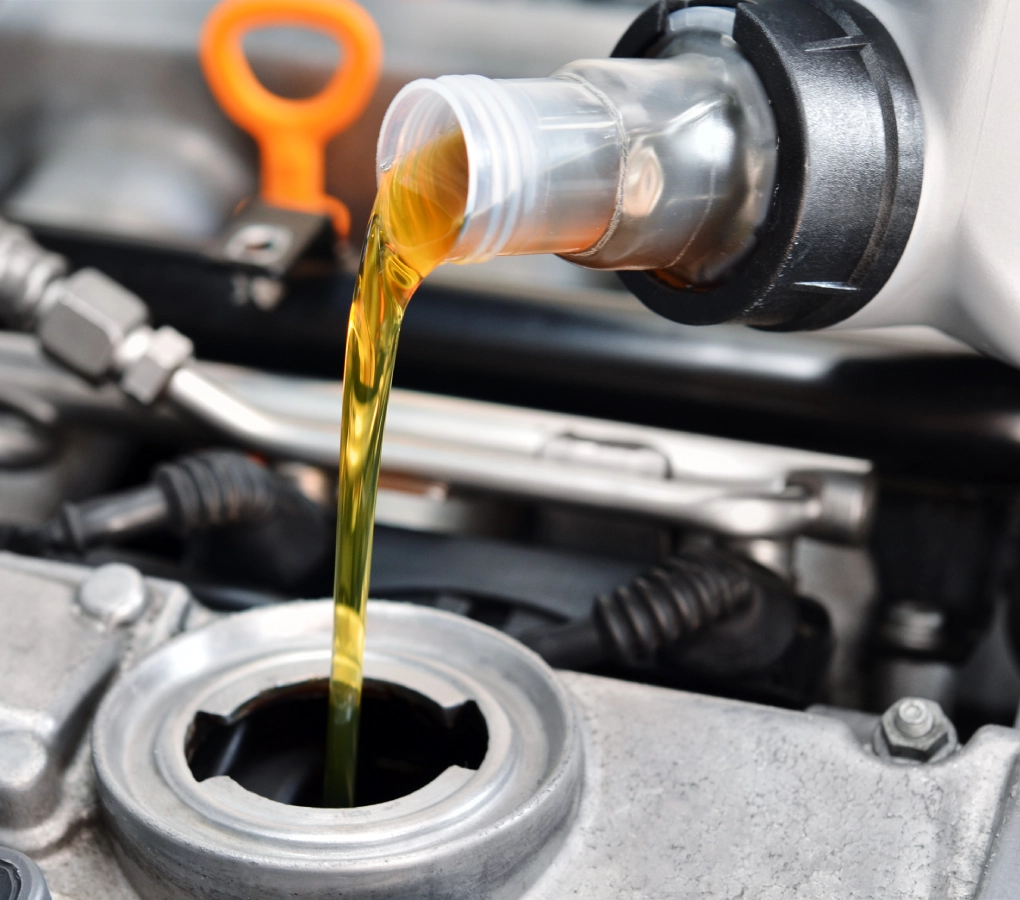 Pouring engine oil into car engine.