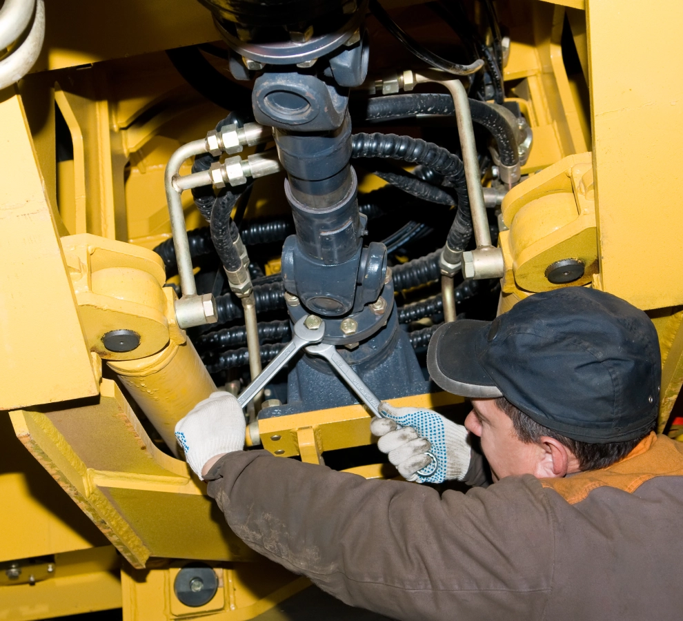 Mechanic working on heavy machinery components.