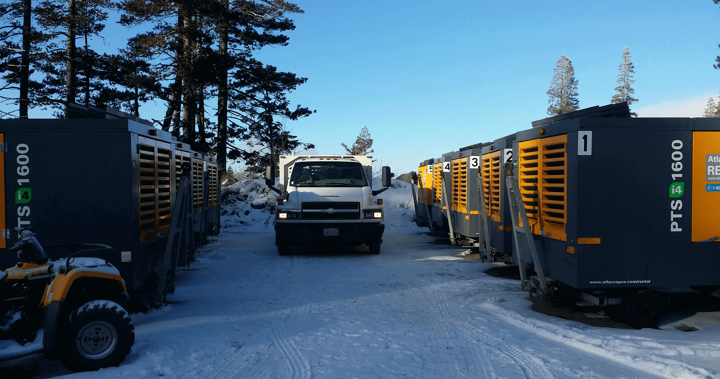 Truck and equipment on snowy road.