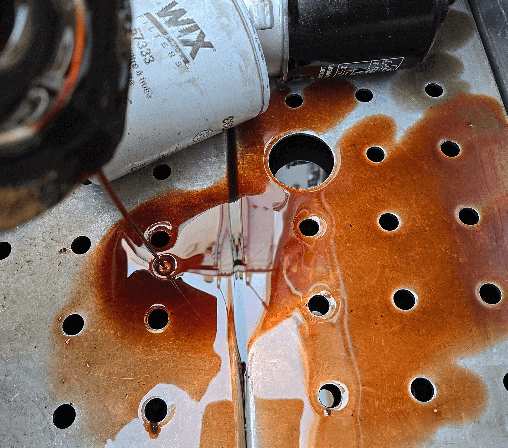 Spilled oil and filter on metal surface.